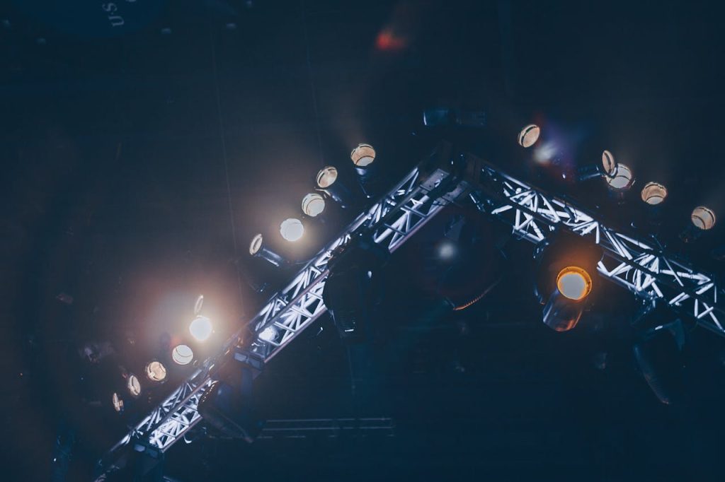 pexels photo 976862 Bright stage lights illuminate a concert venue, creating a vivid and celebratory atmosphere.